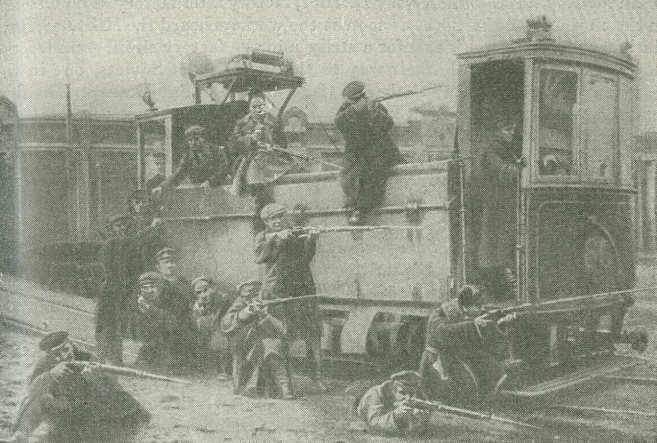 Photograph of Red Guards sitting on and kneeling next to a tramcar, aiming their rifles
